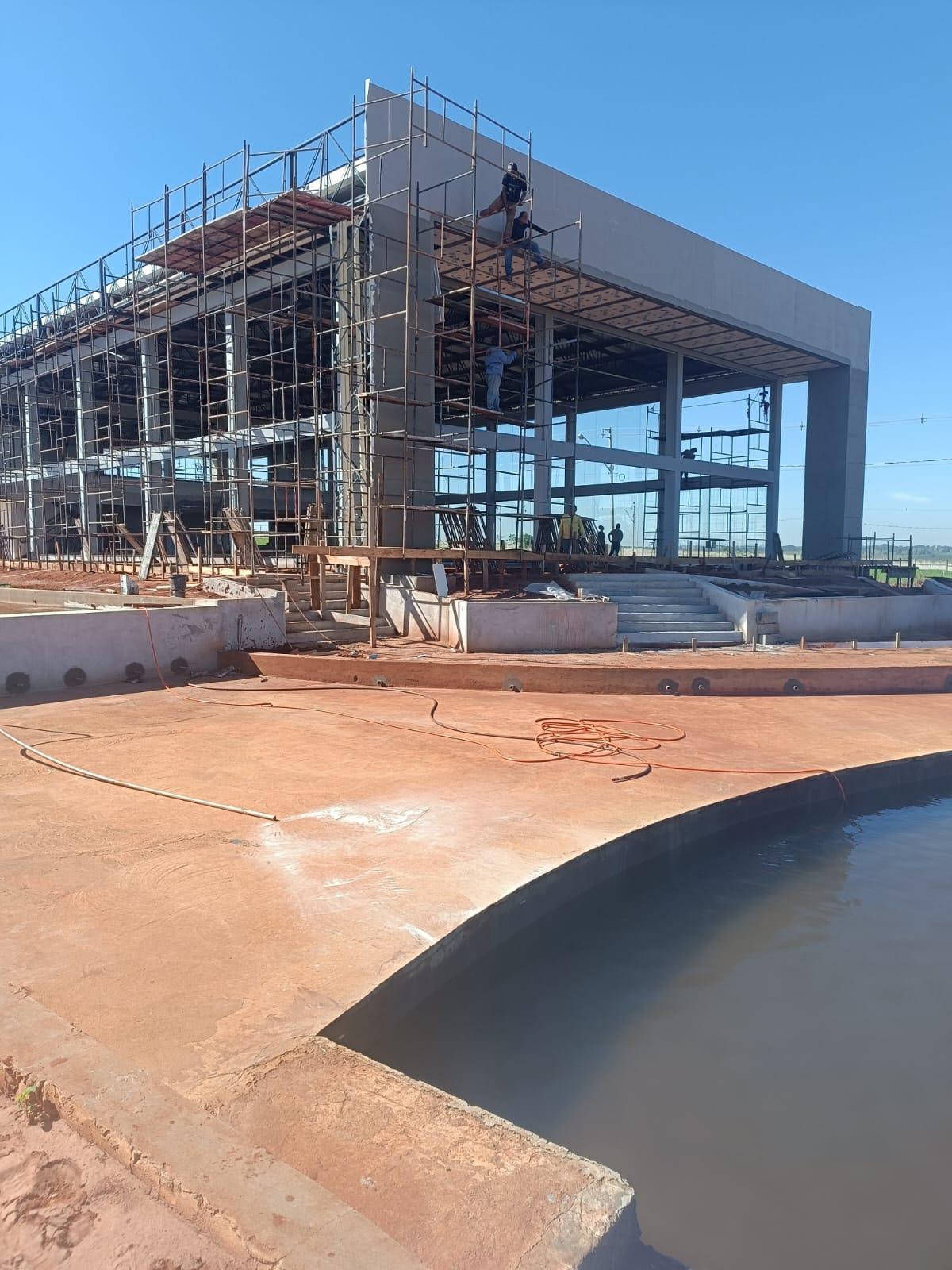Obra de edificação com estrutura, andaimes e área externa