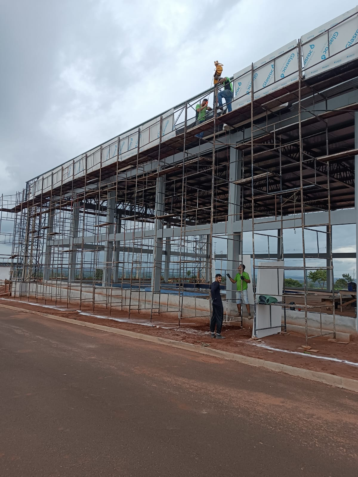 Trabalhadores instalando elementos de fachada em uma obra